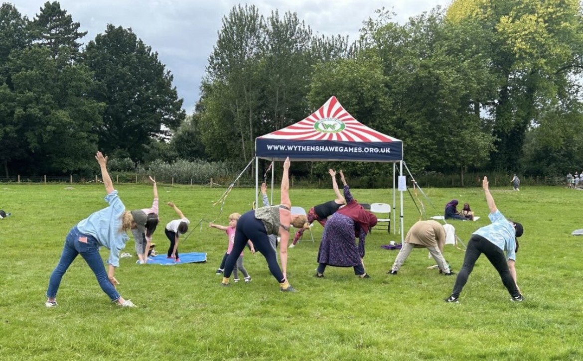 Sophia teaching an outdoor yoga session under a gazebo
